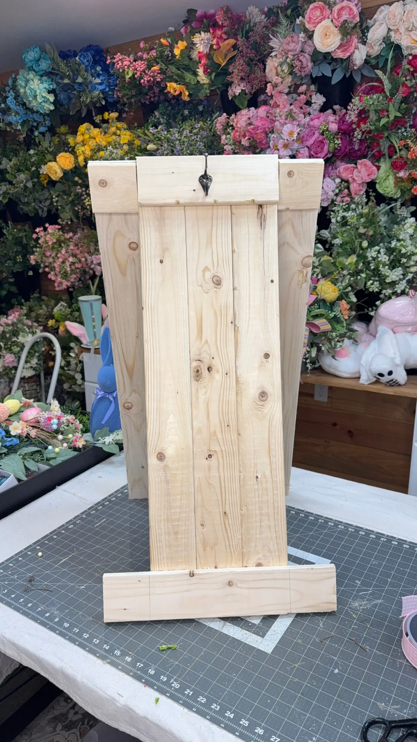 The wreath-making easel holding a finished wreath as a display and photography stand