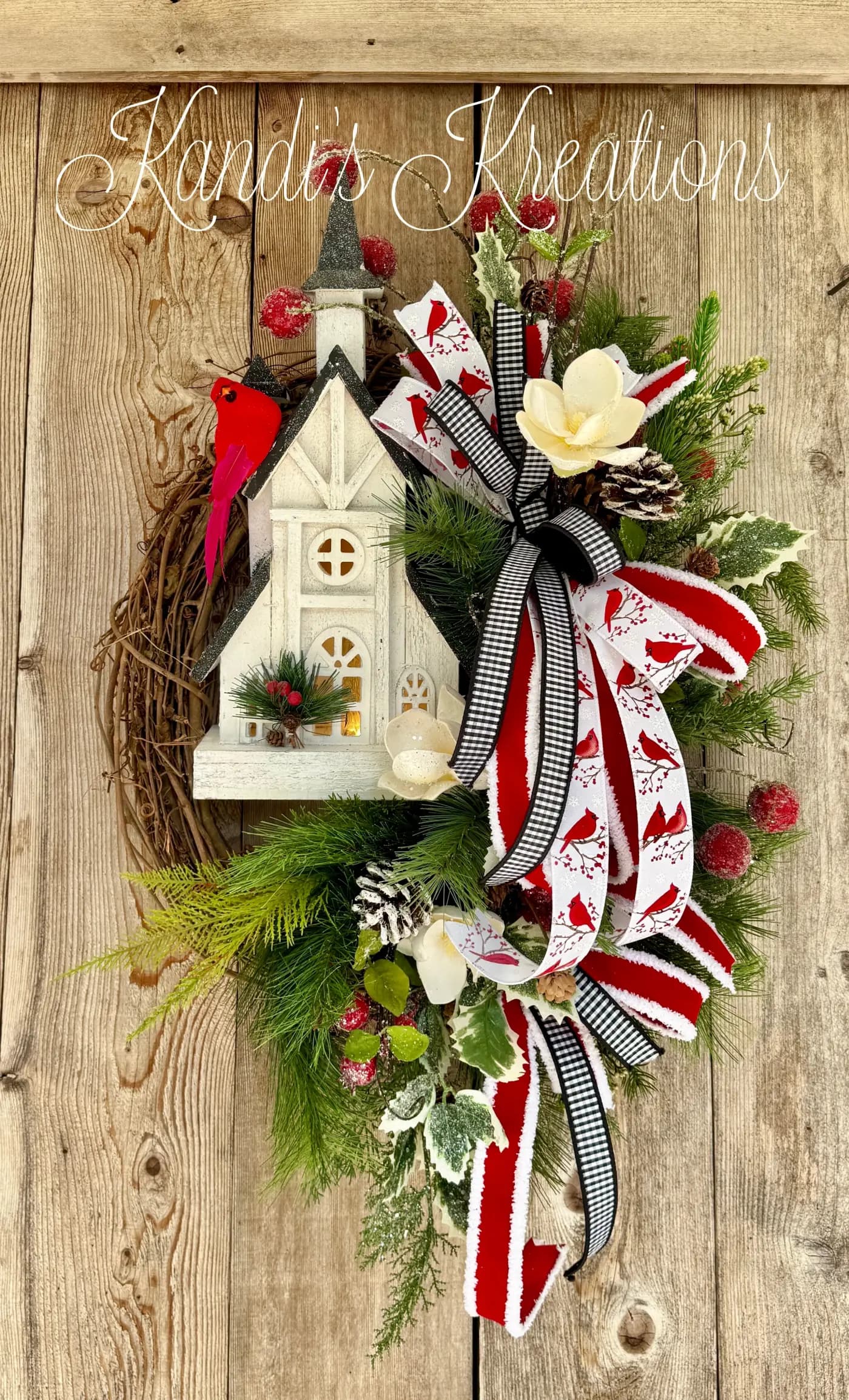 Detail of the lighted white church on a cardinal grapevine wreath